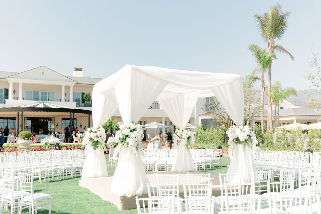 Decoración de boda en tonos Cloud Dancer con manteles blancos cálidos, velas y arreglos florales sutiles