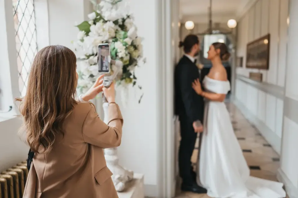 Wedding content creator profesional capturando contenido vertical con smartphone durante una ceremonia de boda