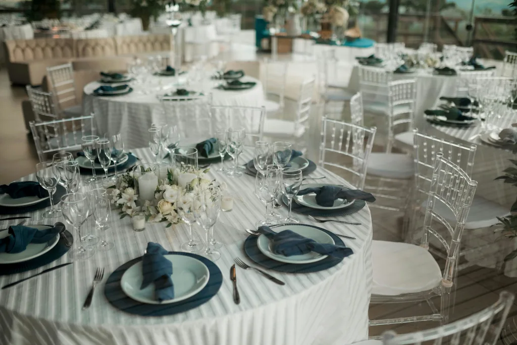 Vista aérea de mesas serpenteantes decoradas con flores y velas en un banquete de boda al aire libre